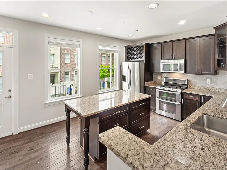 Gourmet Kitchen with Granite countertops, stainless appliances, and access to outdoor balcony