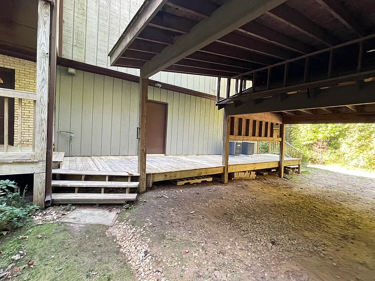 Steps leading up to the front deck and view of the covered parking.