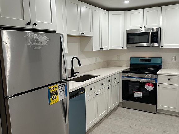 Updated kitchen with new appliances, including refrigerator, dishwasher, microwave, oven and stacked washer/dryer.