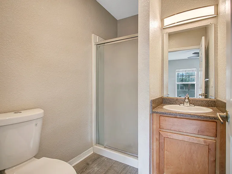 bathroom with shower, toilet, and sink