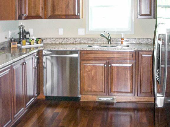 Kitchen with cherry cabinets and hardwood floors - window above sink