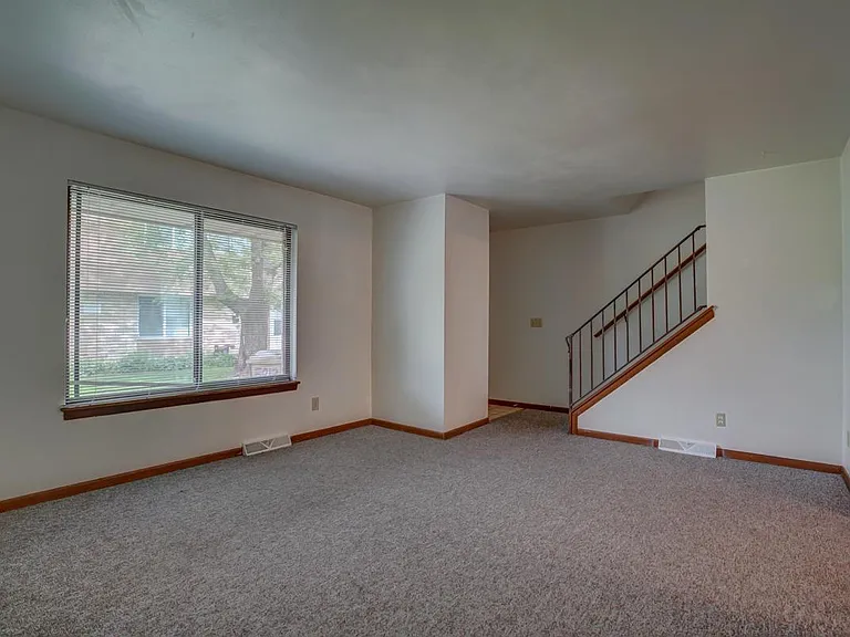 Living room; front entrance by stairs has a coat closet