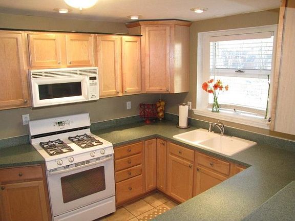 Kitchen is remodeled, bright, solid surface counters, tile, recessed lighting