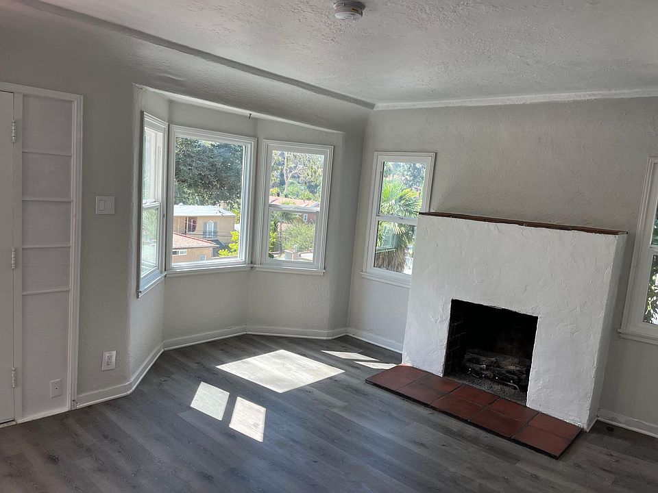 Open Living Space with gas burning fireplace and lots of windows viewing the lake