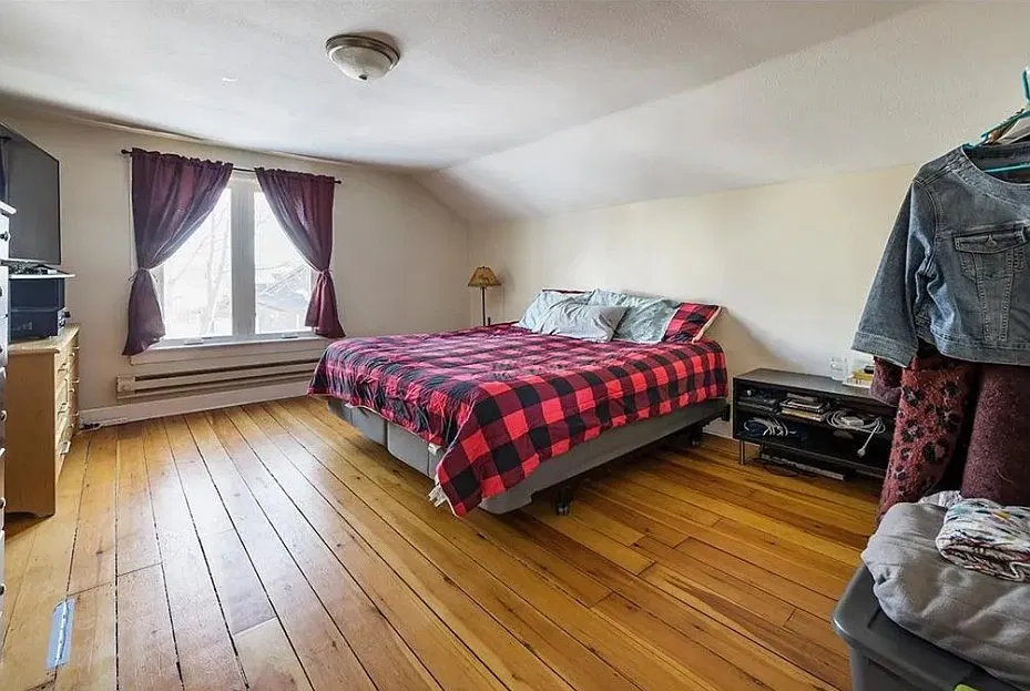 Spacious light-fill main bedroom with original hardwood floors.