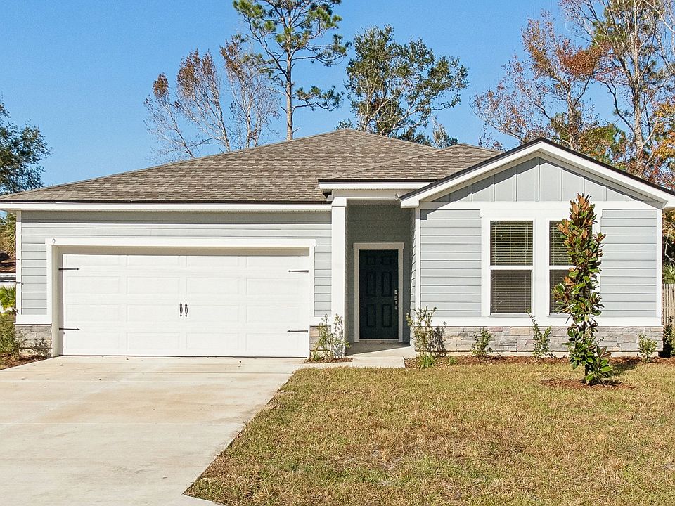 Elegant gable roof and modern gray facade enhance this Palm Coast residence s exterior allure.