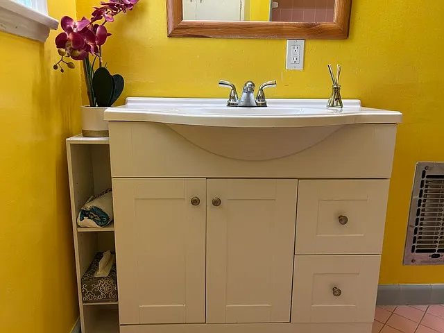 The bathroom boasts vanity sink with extra storage