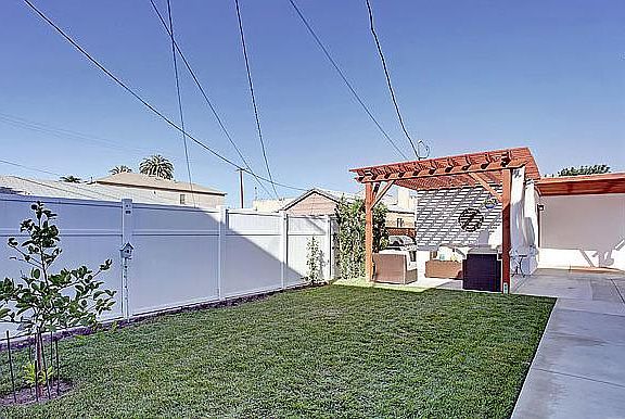 Backyard with gazebo, patio furniture, and BBQ amenities. Lemon tree!