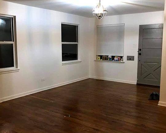 Living room with hardwood floors throughout, fresh paint, and new lighting.