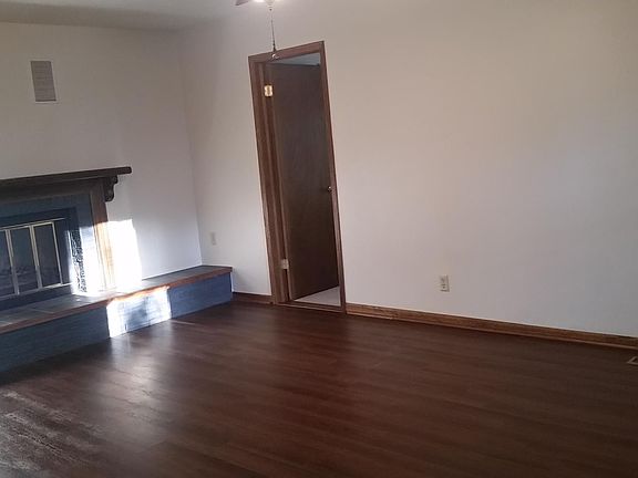 Living room with a wood burning fireplace and new flooring