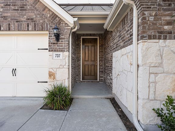 Tall entrance door with brick walls