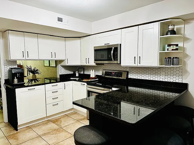 The heart of the home is a beautifully remodeled white kitchen, where clean lines and timeless finishes create a bright, modern space. Warm, heated floors add a touch of luxury and comfort_perfect for chilly winter mornings or cozy evenings at home.