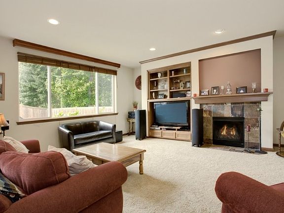 Living room has gas fireplace with slate surround & built in media center. Overlooks backyard patio.