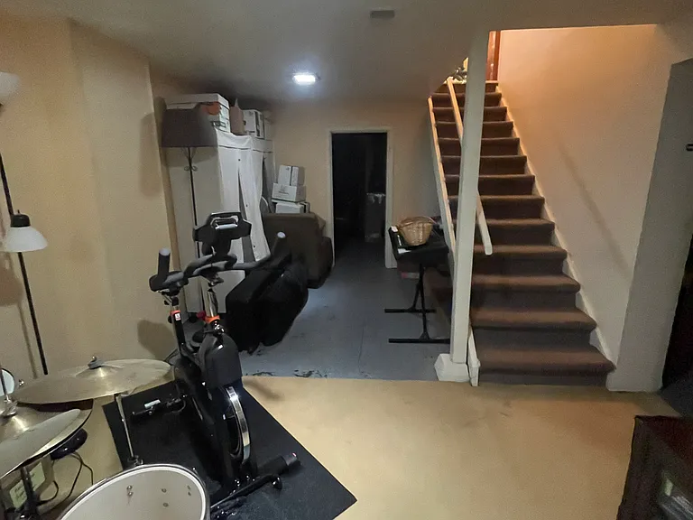 Basement showing storage room and storage space under stairs. Facing east.