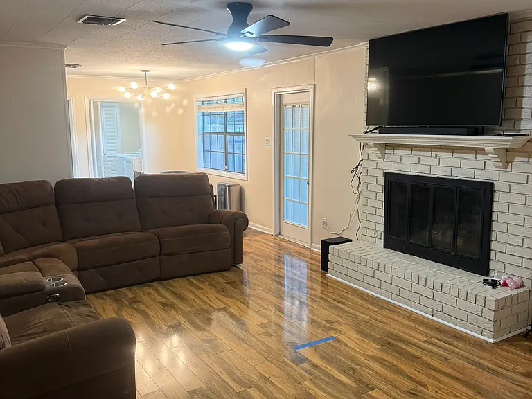 living room with tv and dart board and fireplace