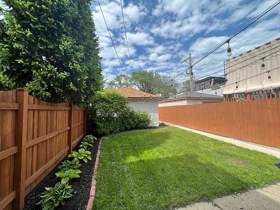 Fenced-in backyard with patio including table/chairs