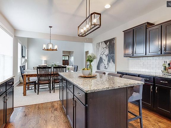 Kitchen with island/bar seating and open concept dining room