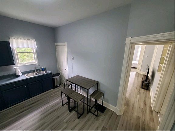 Kitchen view looking into living room - trash can and table will stay as furnished rental