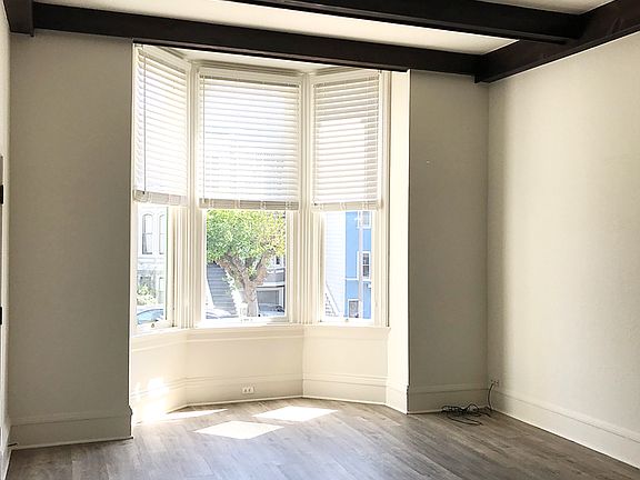 Front Family/Living Room: The large room, has a lot of natural light, bay windows, new flooring and high vaulted ceilings with old world wood beams.