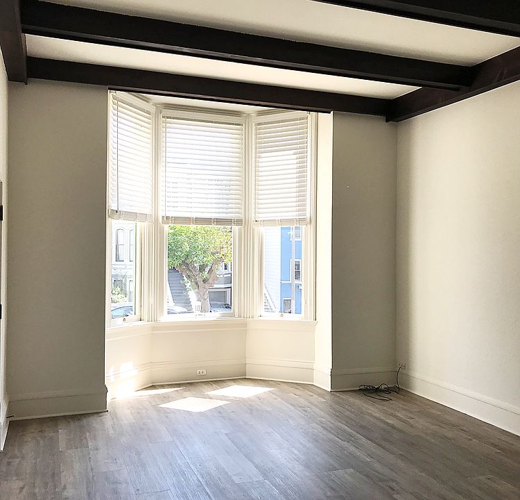 Front Family/Living Room: The large room, has a lot of natural light, bay windows, new flooring and high vaulted ceilings with old world wood beams.