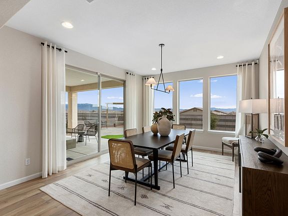 Overhead accent lighting fixtures, large windows, and a sliding glass door accent provide modern bea