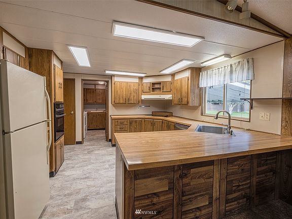 Kitchen with new vinyl floors, breakfast bar, pantry and plenty of cabinet and counter space.