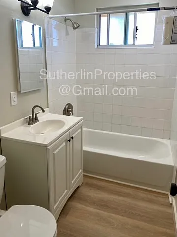 Bathroom with storage vanity, medicine cabinet, and soaker tub with shower combination