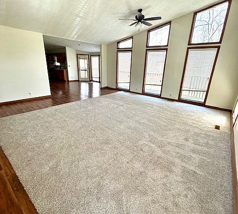 Large vaulted living room with creek views and new carpet