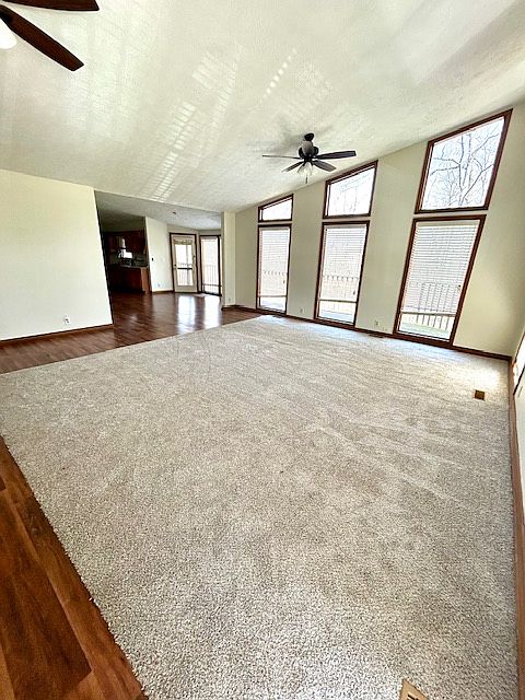 Large vaulted living room with creek views and new carpet
