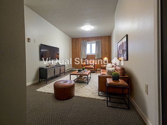Livingroom is approx. 11ft 4in wide with warm wood paneled accent wall.

photo was virtually staged for layout inspiration