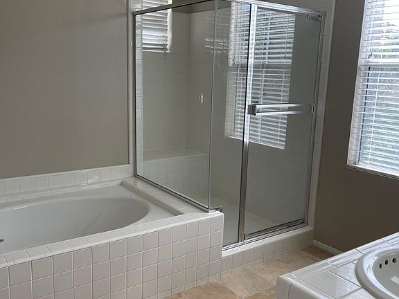 Master shower and tub with travertine floors