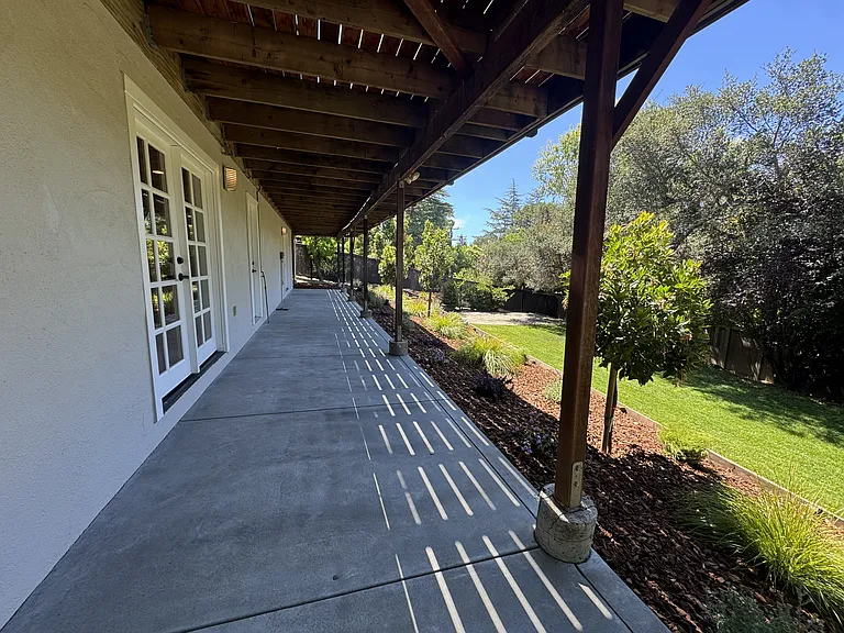 concrete patio adjacent to bedroom 4 and Family/den/office/game room.