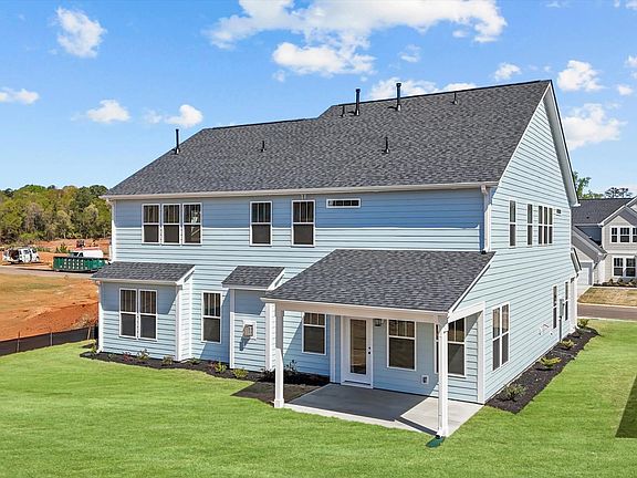 Light blue exterior two story home with rear covered porch at Wells Crossing by DRB Homes in Seneca,