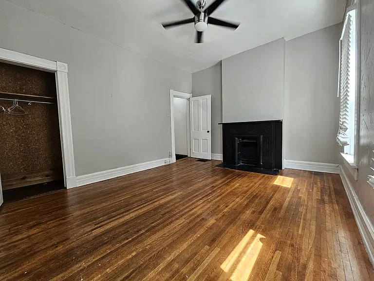 View from the corner of the master bedroom. Modern light fixture/fan and a beautiful decorative marble fireplace.