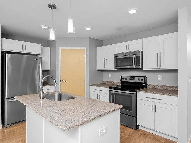 Modern kitchen with sleek white cabinetry, stainless steel appliances, and a chic central island with granite countertops and pendant lighting. Modern kitchen with sleek white cabinetry, stainless steel appliances, and a chic central island with granite c