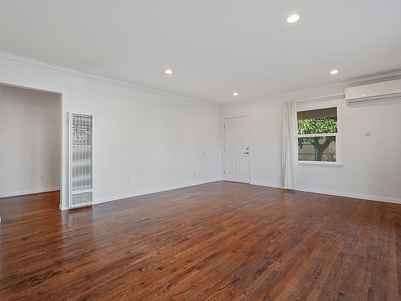 Large living room with lots of natural light, looking toward entrance.