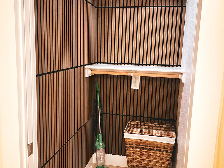 Finished closet with extra storage shelf and extra clothing rod for longer items.