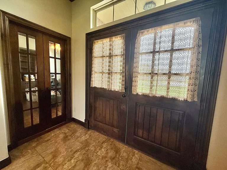 This is the entrance to the home. A neat feature is that, after the door opens, there are latches for the other door to open up both sides allowing easy access to move large items in and out of the home. To the left is the entrance to the library.