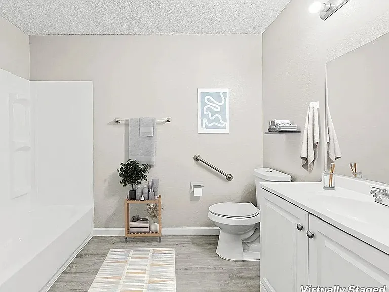 Elegant bathroom with modern fixtures, featuring a sleek white vanity, stylish shelving, and cozy decor. Virtually staged to inspire luxury living.