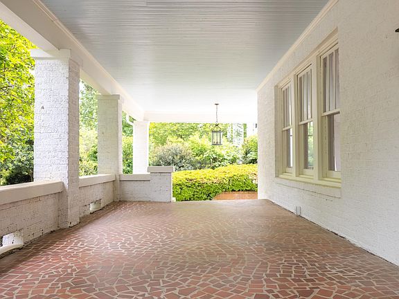 Spacious tiled front porch and drive through carport
