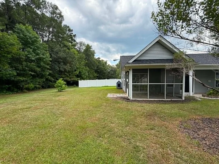 Enjoy indoor-outdoor living from the screened-in porch with elegant marble flooring, overlooking a spacious backyard that's perfect for relaxing or entertaining.
