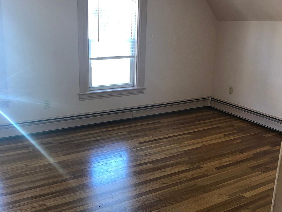 Right side of large master bedroom seen from the doorway. Notice the ceiling fan, bright windows, and beautiful wood floor.