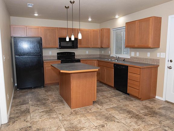 Kitchen - interior is done in warm brown and grey tones - refrigerator, stove, microwave, dishwasher, disposal