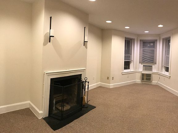 Another view of front room, highlighting fireplace