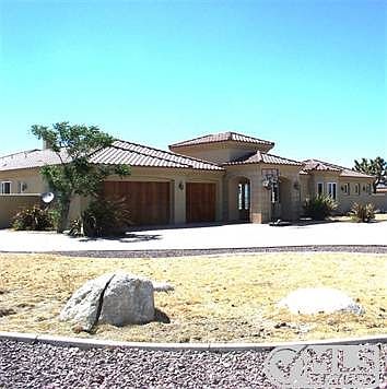 Front of home with curbing and rocks.