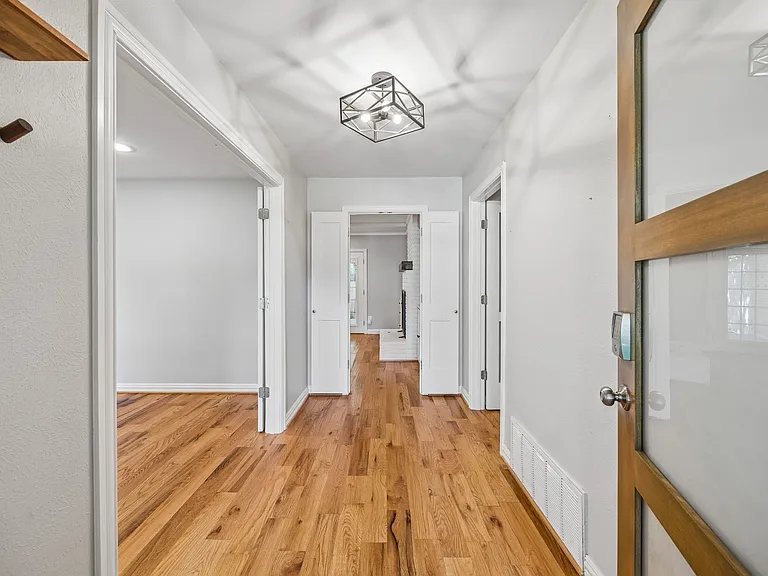 Entryway featuring wood-finish flooring, a modern geometric ceiling light fixture, recessed lighting, and a glass-paneled wooden entry door