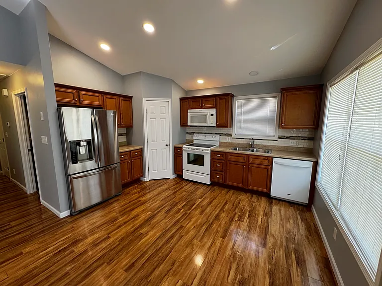 Main kitchen view with an over the range microwave, stainless steel refrigerator and a dishwasher so you can spend less time cleaning and spend more time doing what's important to you.