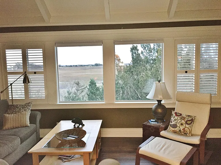 A closer look at the Great room windows with shutters and shades to cut the sun for movie viewing.