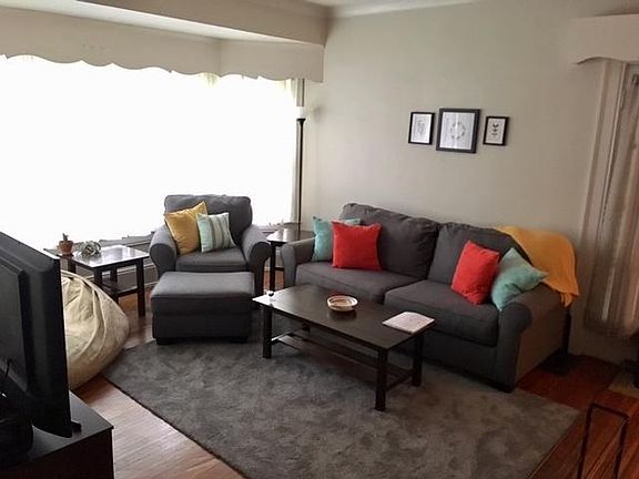 Open floor plan with large living and dining spaces featuring built-in cabinets and shelves, and a bay window for a reading bench/nook.