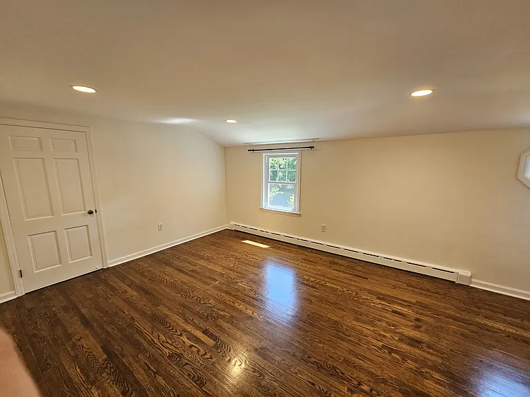 1st Floor Bedroom 3 _ View 1
Bedroom with hardwood floors, recessed lighting, natural light, and a storage closet with a large shelf and hanging rod.